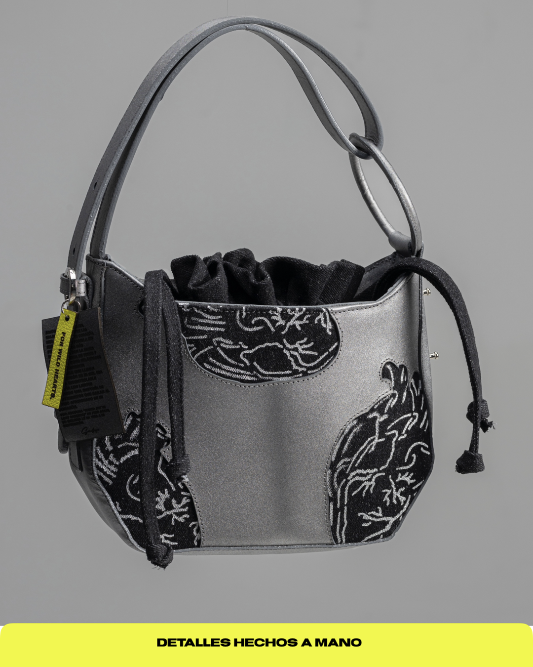 Bolso en cuero color plomo y denim negro con corazones anatómicos pintados a mano.