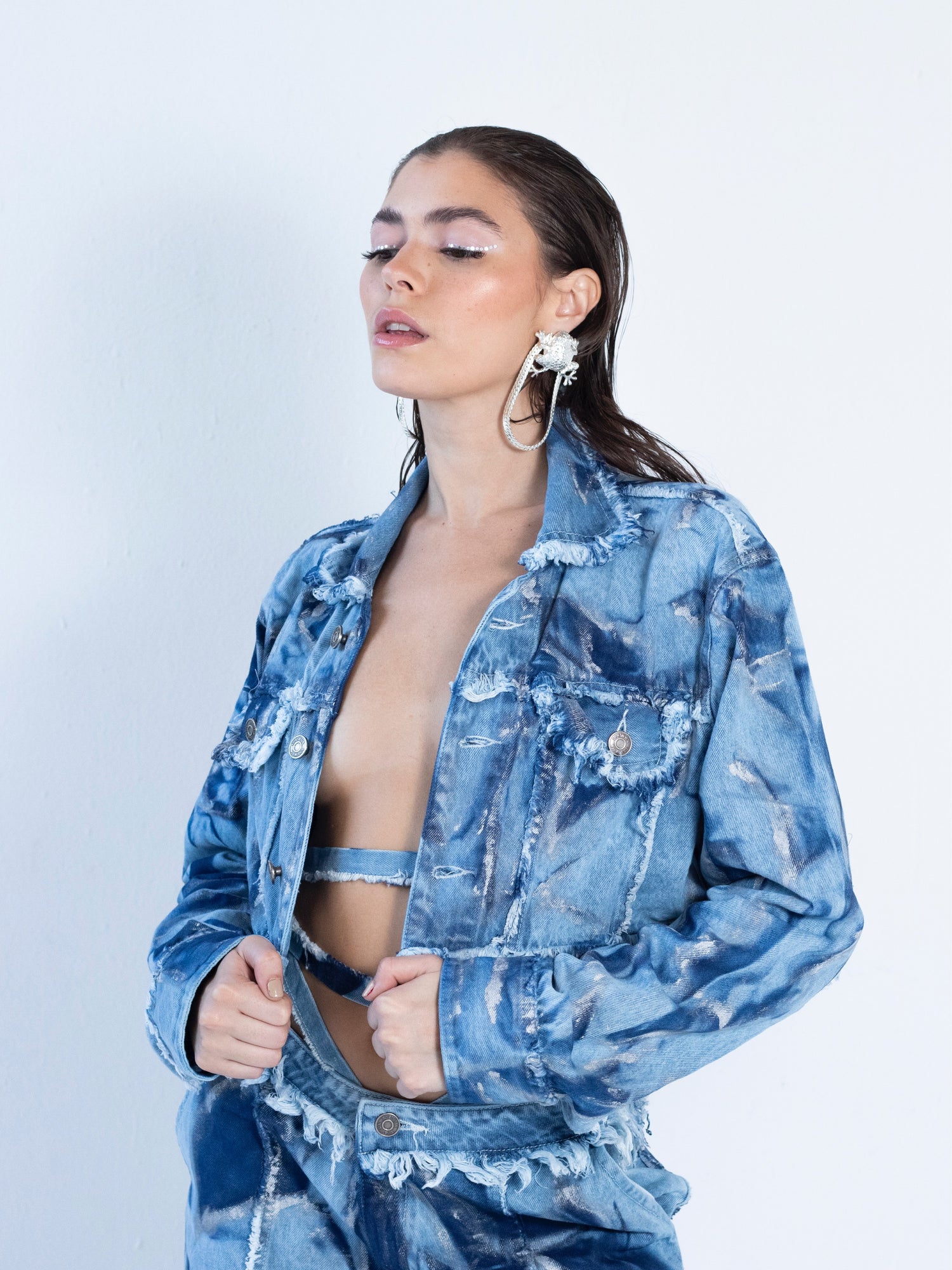 Chaqueta en denim claro con tie dye en azul oscuro y detalles plateados.